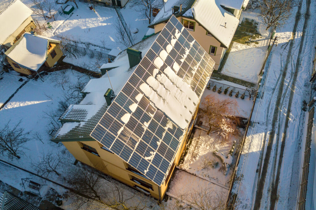 house roof covered with solar panels in winter wit